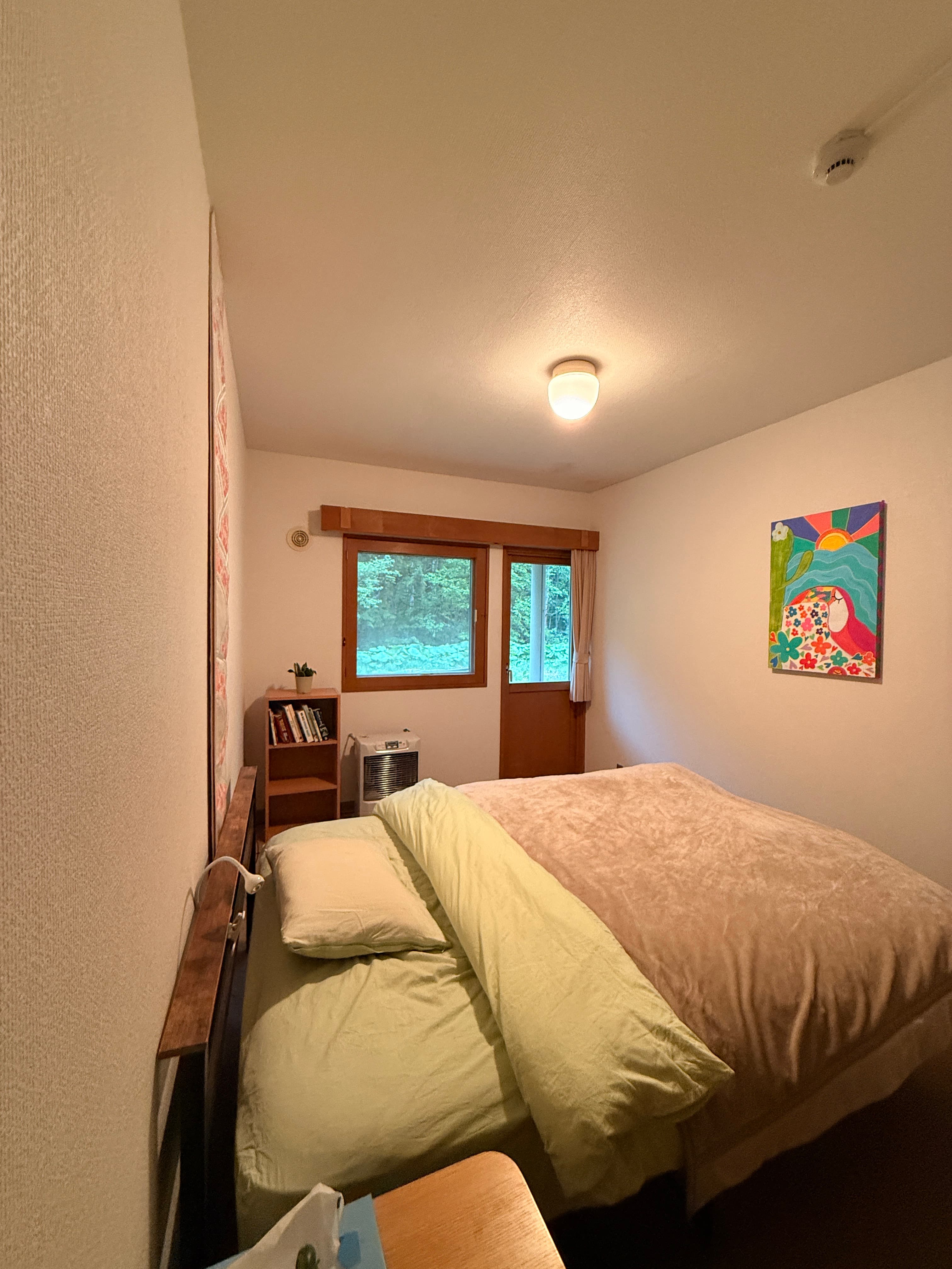 A queen room at Wakaranai Lodge with simple bedding and warm light.