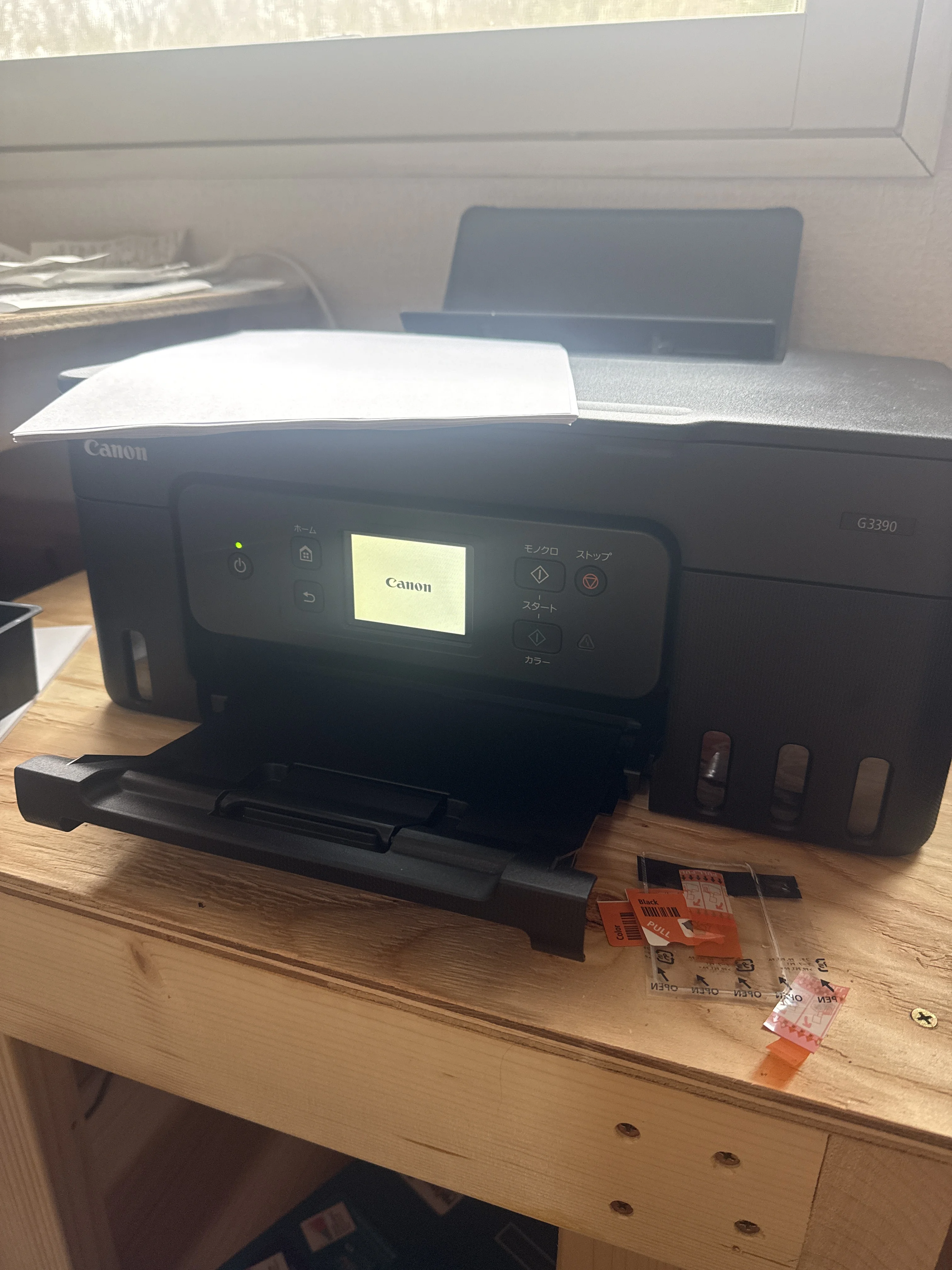 Canon printer on a wooden desk ready for printing