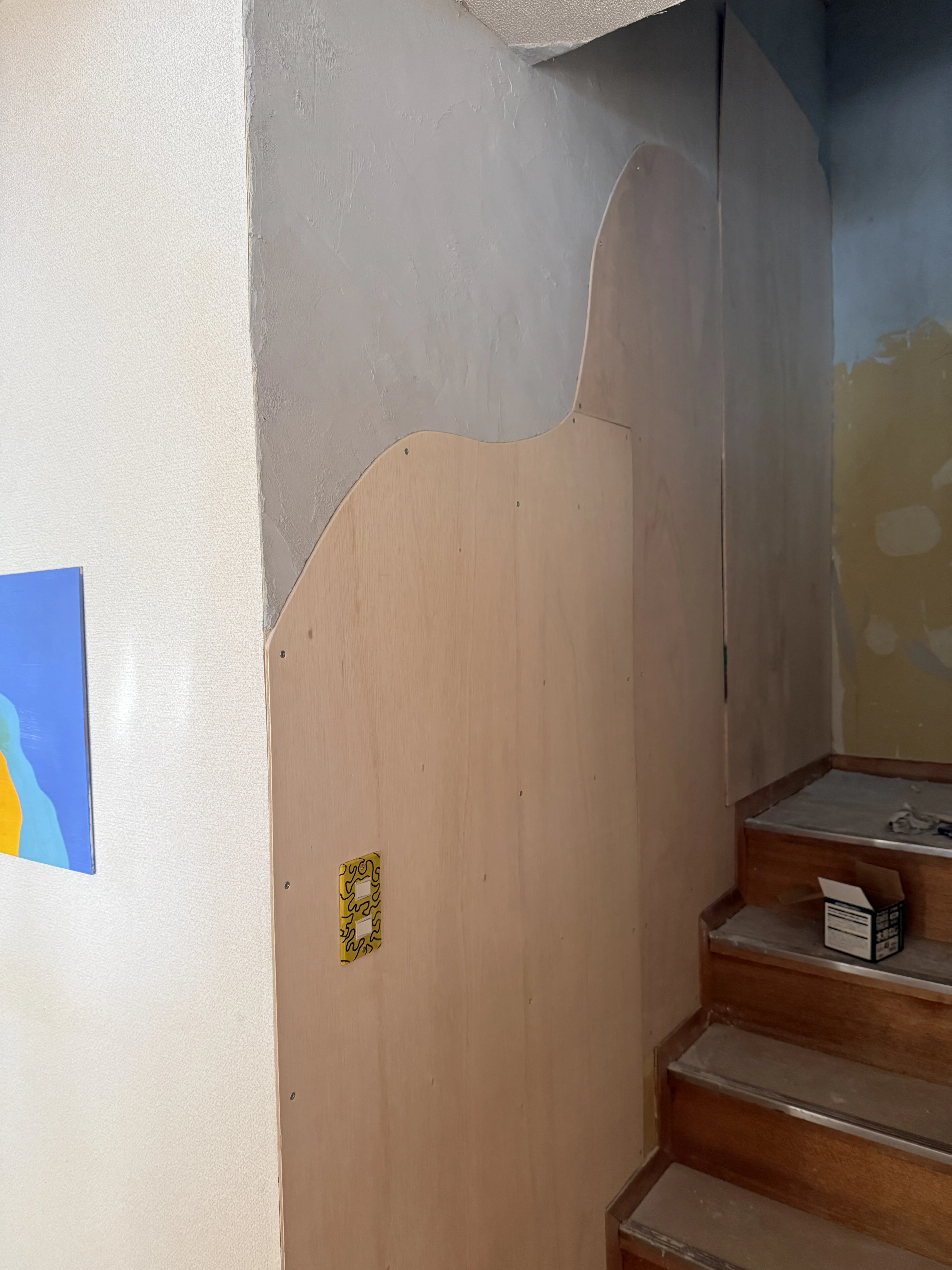 plywood wave cut along shikkui wall by the stairwell